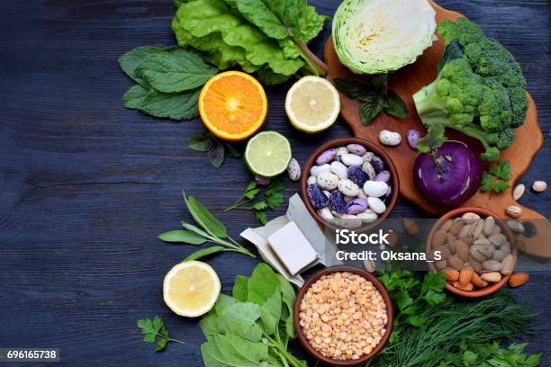 Composition On A Dark Background Of Products Containing Folic Acid Vitamin B9 Green Leafy Vegetables Citrus Beans Peas Nuts Yeast Top View Flat Lay Stock Photo - Download Image Now