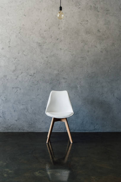 istock electric bulb and modern white chair on the floor at empty room 696170272