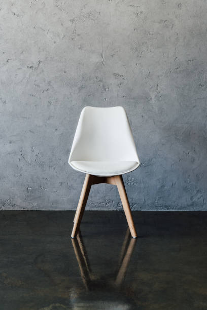 istock Empty modern white chair near grey wall in minimalistic style 696170604