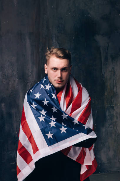 istock Man is covered by american flag on dark background 696174232