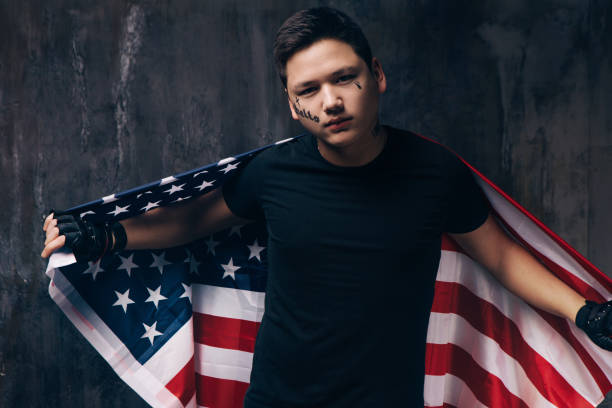 istock Tattooed guy with US flag on dark background 696174404
