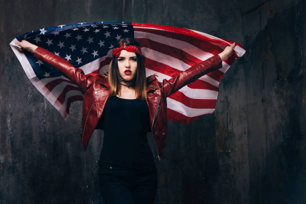 istock Girl with flying american flag behind the back 696174502