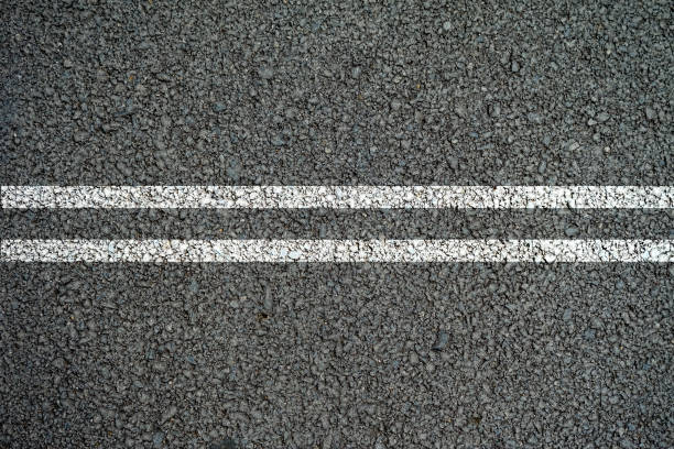 двойные белые линии на асфальтовой дороге посередине. - double lane стоковые фото и изображения