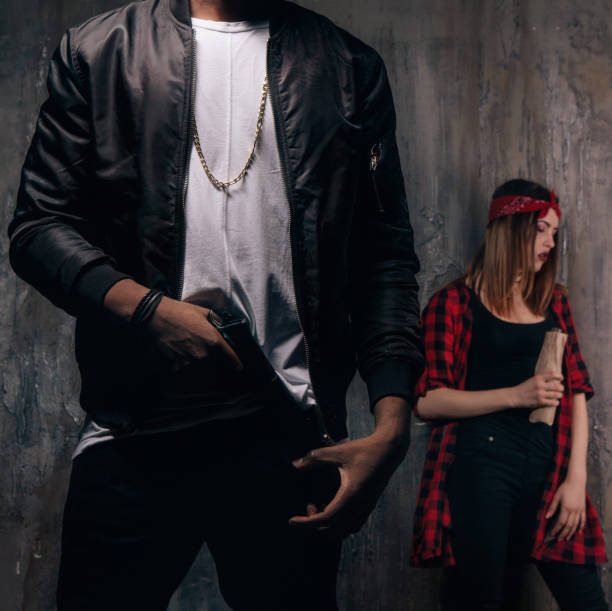istock Guy with gun and girl with alcohol 696177764