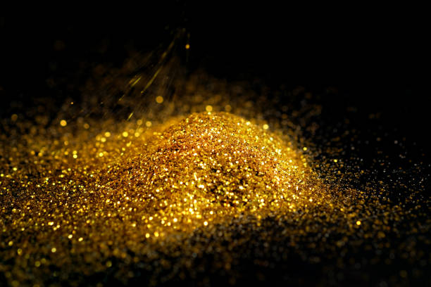 istock Sprinkle glitter gold dust on a black background with copy space 696180994