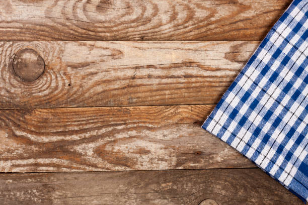istock blue checkered tablecloth on the old wooden table with copy space for your text. Top view 696183372