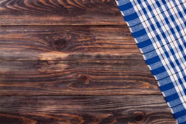 istock blue checkered tablecloth on the black wooden table with copy space for your text. Top view 696183508