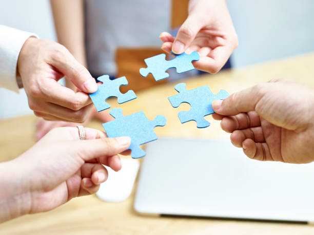 istock businesspeople putting jigsaw pieces together 696186062