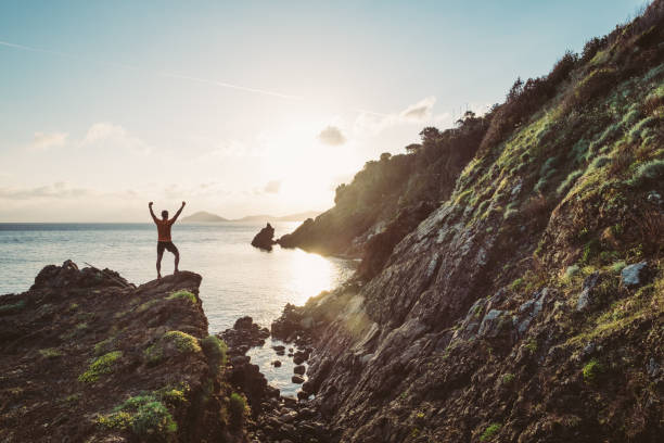istock Man hiking on a mountain over the sea 696189500