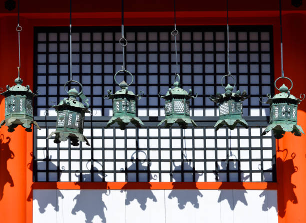 Nara, Japan - June 13, 2017: Rows of metal lanterns hanging in Kasuga Taisha Shrine, Nara, Japan, casting their shadows on a wall