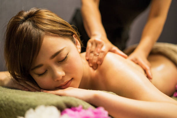 jovem mulher recebendo massagem com óleo - asian ethnicity asia massaging spa treatment - fotografias e filmes do acervo