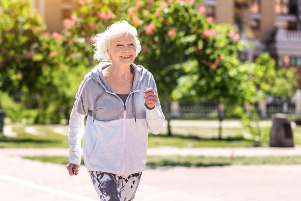 istock Joyful old pretty woman doing morning exercise 696198370