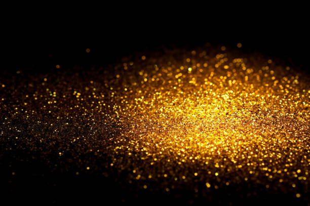 istock Sprinkle gold glitter dust on a black background with copy space. 696201882