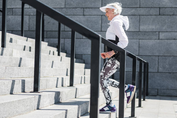 istock Cheerful old lady training to run up concrete stairs 696208932