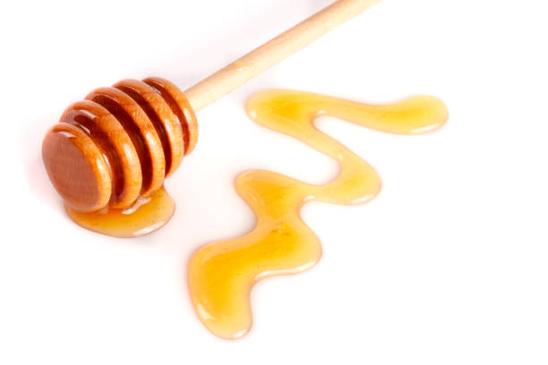 istock Honey stick with flowing honey isolated on white background 696209088