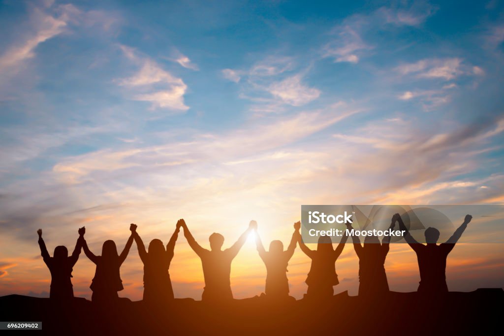 Silhouette of happy business team making high hands in sunset sky background for business teamwork concept Teamwork Stock Photo