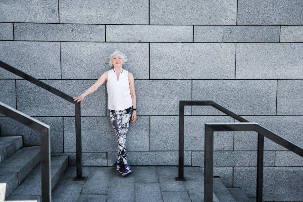 istock Cheerful old lady relaxing after exercise on granitical stairs outdoors 696209614