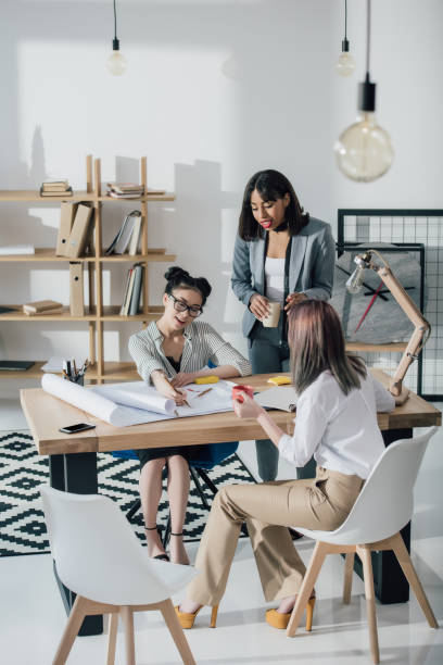 istock Multiethnic group of professional young architects working with blueprints 696210180