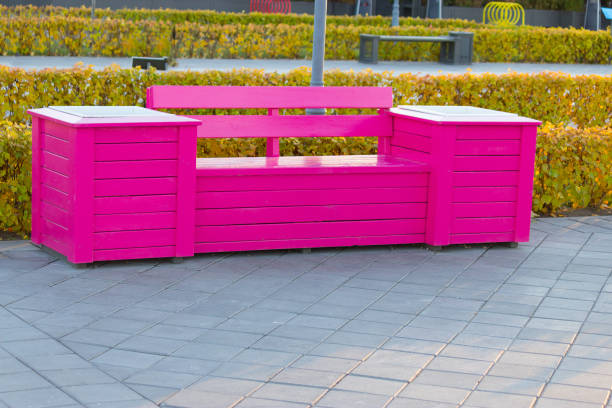 istock Pretty pink bench in front of rows of tulips 696211106