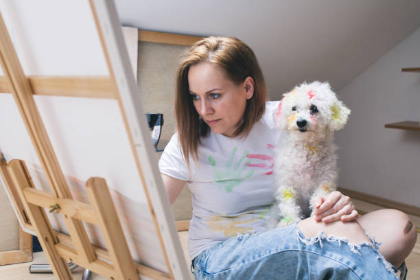 istock Getting creative.woman painting with his dog in his studio 696212484