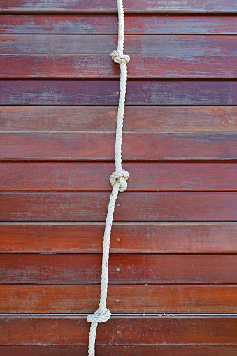 White rope tied in a knot and wood plank for adventure.
