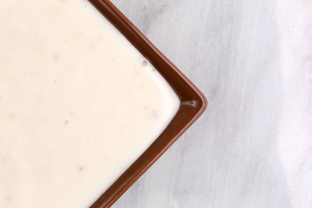 Small dish of Italian salad dressing on marble table top