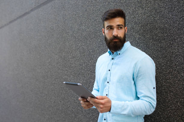 istock Young hipster businessman holding digital tablet 696230140