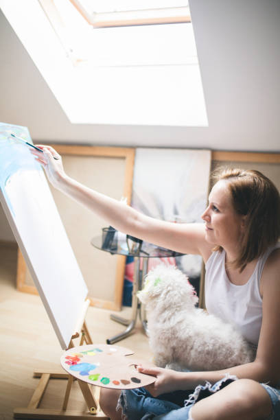 istock Getting creative.woman painting with his dog in his studio 696230828