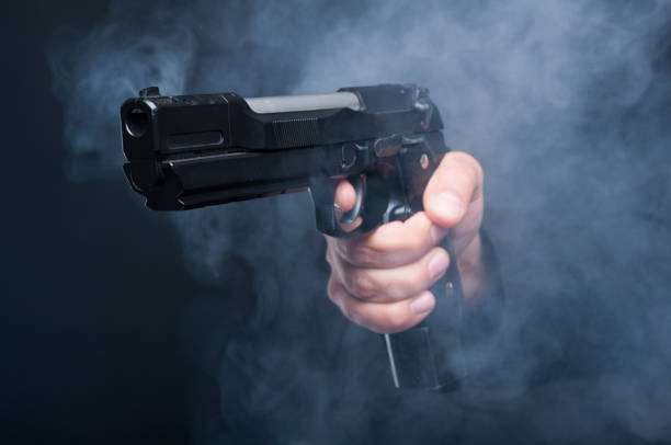 istock Closeup of gun in boss mafia hand 696236164