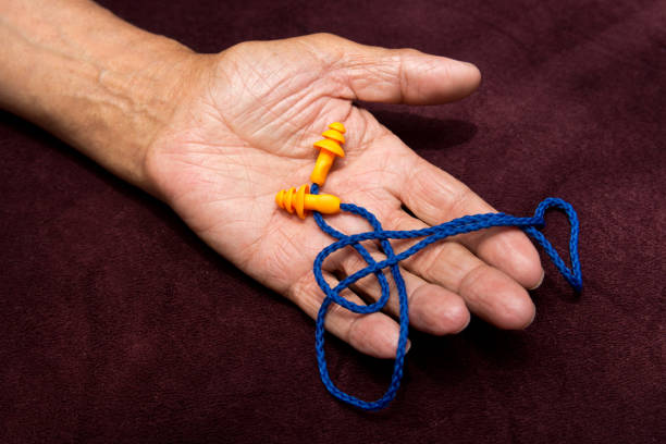 istock Earplugs In the hands of an elderly man. 696246092