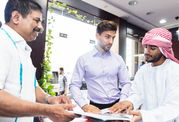 istock Young Arab requesting for a suit from the catalog to be made in his measurements 696246946