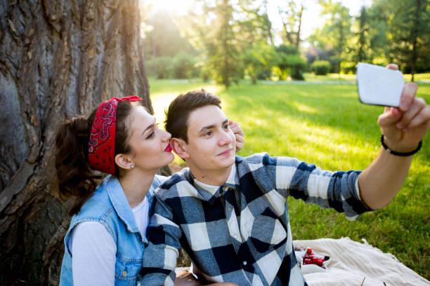 istock Happy couple taking selfie with cell phone at picnic 696247704
