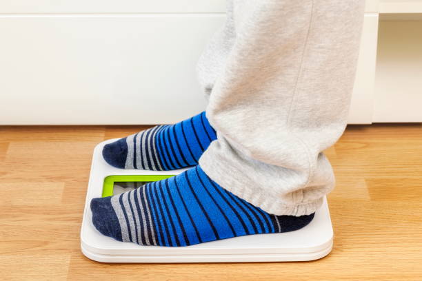 istock Male in socks and lounge pants on digital scale 696247808