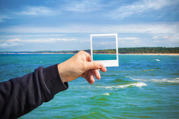 istock Man with seascape photo on same sea background 696247874
