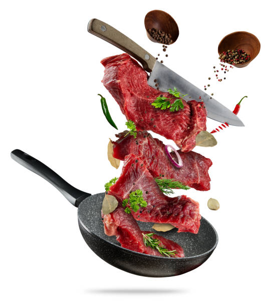 istock Flying raw steaks with cooking ingredients from pan 696248260