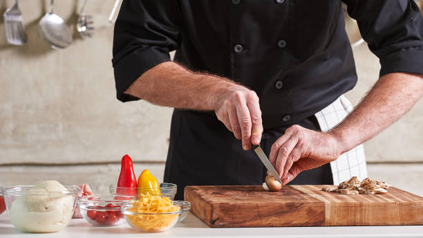 istock Restuarant hotel private chef cutting mushrooms on board 696251974