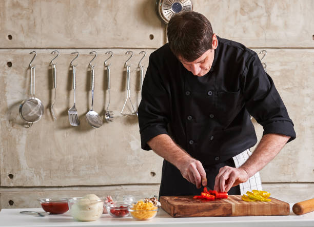 istock Restuarant hotel private chef cutting red pepper on board 696254812