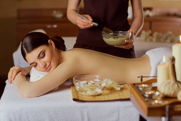 istock Young woman is put on a mask on her back in  spa salon 696254848