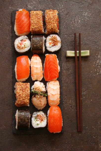 istock sushi and sushi rolls, sushi nigiri on stone plate 696258122
