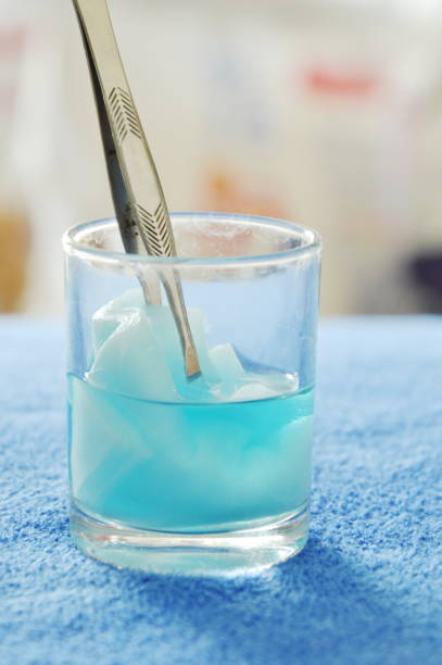 istock cotton wool with tweezers picking in blue hydrogen peroxide 696261420