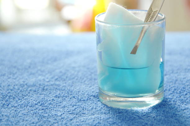 cotton wool with tweezers picking in blue hydrogen peroxide cotton wool with tweezers picking in blue hydrogen peroxide on glass hydrogen peroxide stock pictures, royalty-free photos & images