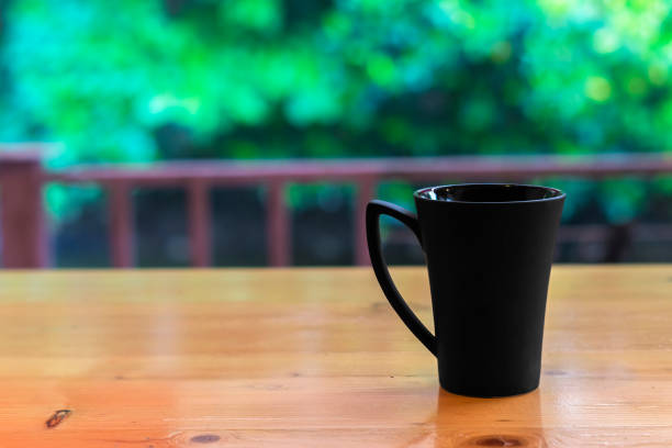 istock Black glass on wooden table. 696264280