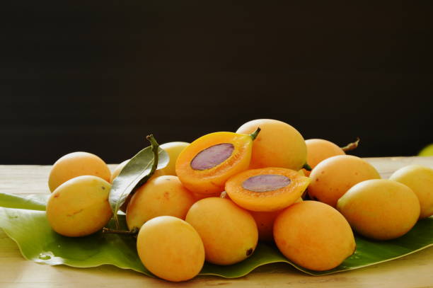 istock Marian plum tropical fruit half cut on black background 696264702