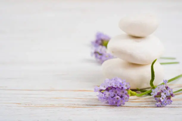 Photo of Stones and twigs with lavender flowers on wooden table