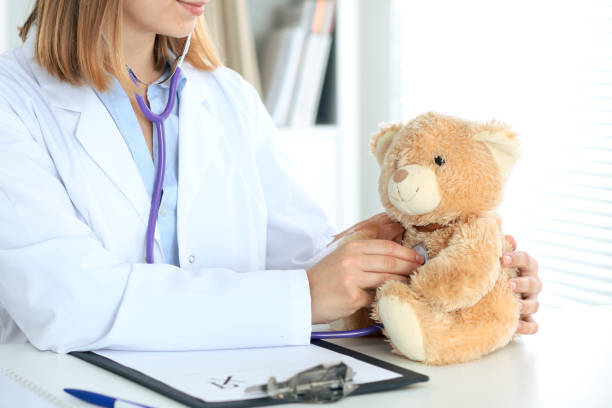 istock Female doctor examining a Teddy bear  patient by stethoscope. 696265348