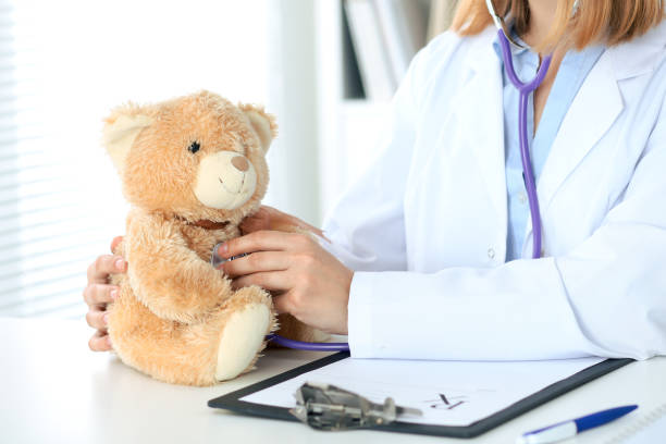 istock Female doctor examining a Teddy bear  patient by stethoscope. 696265368