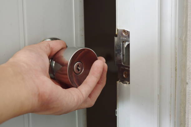 istock hand twisting silver knob to opened door in dark room 696265700