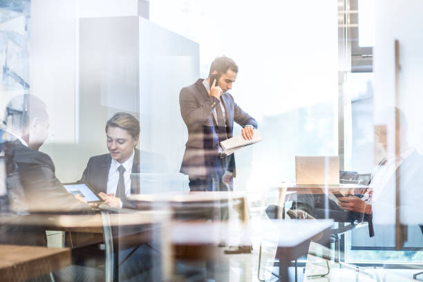 istock Businessman talking on a mobile phone on corporate office. 696266128