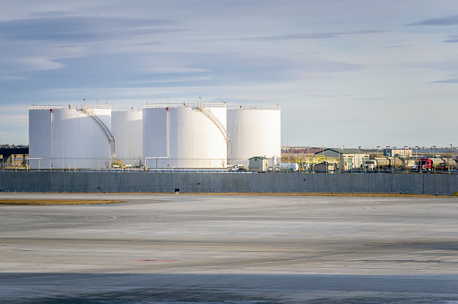 White Fuel Storage Tanks in near a Taxiway at Calgary Airport on a Winter Day