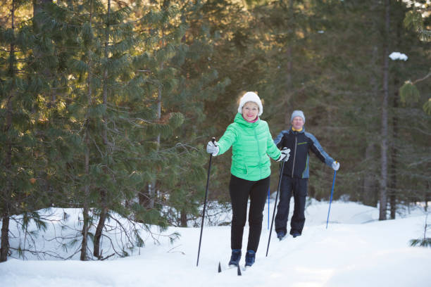 istock Active senior couple on a ski vacation in winter forest. 696268644